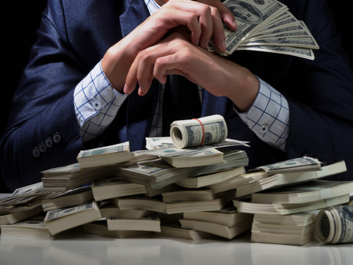 Young,Man,Holding,Cash,In,Hands.business,Man,Counts,Money,On